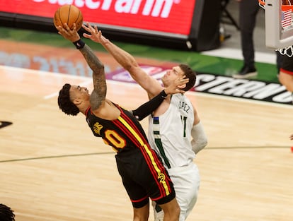 Brook Lopez tapona un lanzamiento de John Collins en el partido Milwaukee-Atlanta.