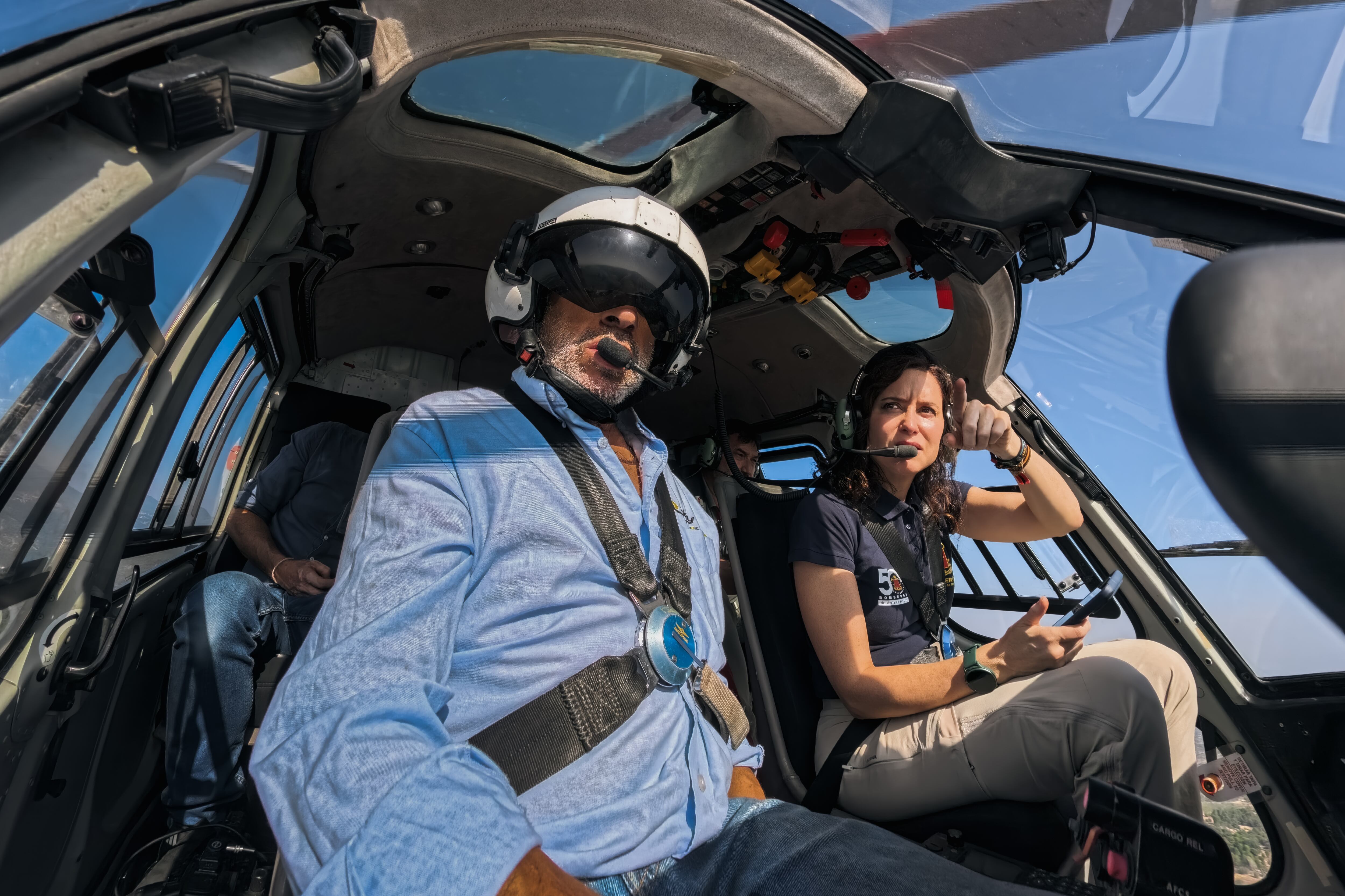 Foto distribuida este jueves por la Comunidad de Madrid en la que se ve a la presidenta, Isabel Díaz Ayuso, sentada en un helicóptero junto al director de la Agencia de Emergencias 112, Pedro Ruiz.