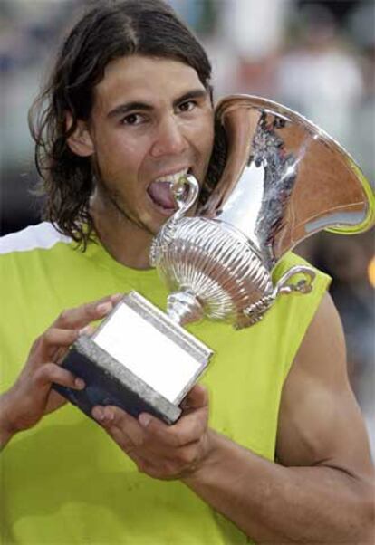 Rafael Nadal posa mordisqueando su trofeo tras imponerse a Roger Federer en la final del torneo de Roma.