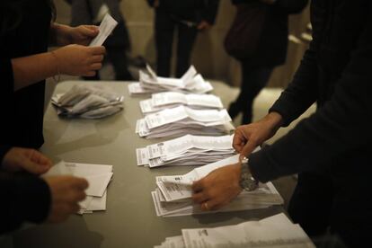 Los miembros de una mesa electoral ordena las papeletas por partidos.