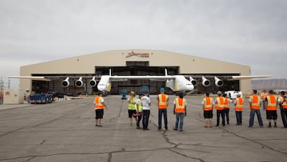 Los miembros del proyecto miran al avión mientras sale del hangar por primera vez en el desierto de Mojave, California.