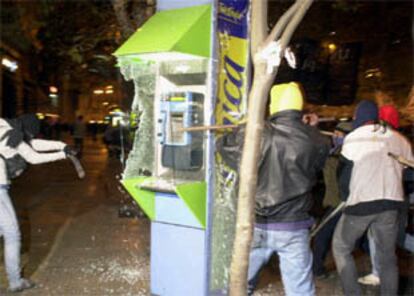Unos manifestantes destrozan una cabina de Telefónica, en el centro de Buenos Aires.