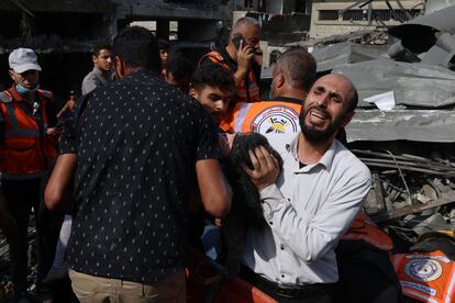 Un hombre lloraba este domingo mientras sujetaba el cadáver de su hija rescatado de entre los escombros de su vivienda en Rafah.