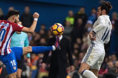 Yannick Ferreira Carrasco (izquierda) del Atletico Madrid golpea el balón frente a Gareth Bale.
