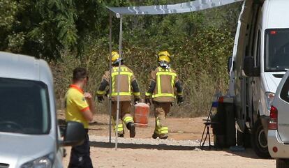 Dos bomberos trasladan una bombona de butano.