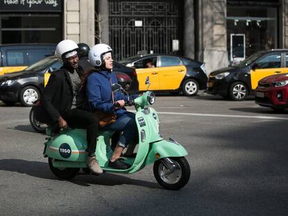 Usuaris d'una moto de lloguer per minuts, a Barcelona. 