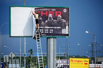 Retirada de un cartel de Wagner bajo el lema "Únete a Wagner" en una carretera de San Petersburgo (Rusia), este sábado. 