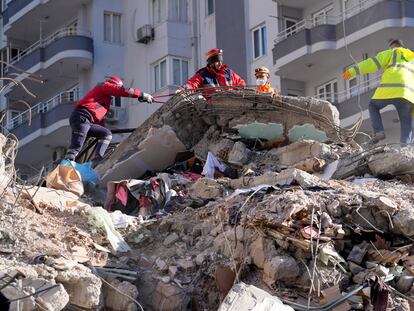 Emergency teams search for people in the rubble in a destroyed building in Adana, southern Turkey, Tuesday, Feb. 7, 2023. A powerful earthquake hit southeast Turkey and Syria early Monday, toppling hundreds of buildings and killing and injuring thousands of people. (AP Photo/Hussein Malla)