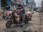 -FOTODELDÍA-PIL01. BEIJING, 13/06/2020.- Hombres con máscaras protectoras cargan un scooter con carne al lado del edificio cerrado del mercado Xinfadi en el distrito de Fengtai, Beijing, China, el 13 de junio de 2020. Uno de los mercados más grandes de Beijing, Xinfadi en el distrito de Fengtai, fue cerrado el 13 de junio, y el distrito colocado bajo bloqueo después de la confirmación de nuevos casos de coronavirus domésticos . EFE/EPA/ROMAN PILIPEY