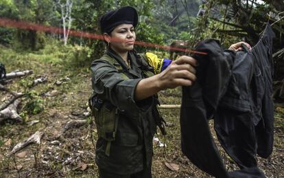 Manuela, a member of the Revolutionary Armed Forces of Colombia (FARC), hangs up her uniform at a camp in the Colombian mountains on February 18, 2016. Many of these women are willing to be reunited with the children they had in the middle of war and then left under protection of relatives or farmers, whenever the imminent peace agreement puts an end to the country's internal conflict.     AFP PHOTO / LUIS ACOSTA