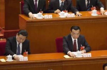 El primer ministro chino, Li Keqiang (d), y el secretario General del Partido Comunista chino, Xi Jinping (i), votan durante el cierre de la sesión anual de la Asamblea Nacional Popular (ANP) este 13 de marzo de 2014 en el Gran Salón del Pueblo, en Pekín (China).