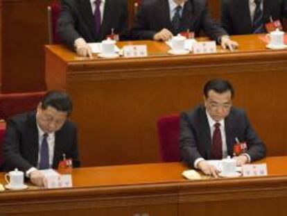 El primer ministro chino, Li Keqiang (d), y el secretario General del Partido Comunista chino, Xi Jinping (i), votan durante el cierre de la sesión anual de la Asamblea Nacional Popular (ANP) este 13 de marzo de 2014 en el Gran Salón del Pueblo, en Pekín (China).
