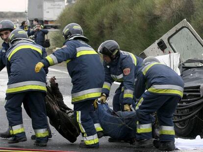 Un grupo de bomberos traslada el cuerpo de uno de los seis fallecidos tras el accidente ocurrido en Torquemada (Palencia).