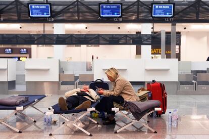 Dos pasajeros descansan en unas tumbones habilitadas en el aeropuerto Internacional Zaventerm, Bruselas.