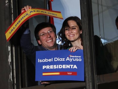 Martínez-Almeida y Díaz Ayuso celebrando su éxito desde una ventana de la sede del PP en la calle Génova.