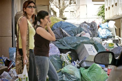 Una ciudadana se tapa la nariz ante el hedor de la basura acumulada en Almería tras una semana de huelga de limpieza.