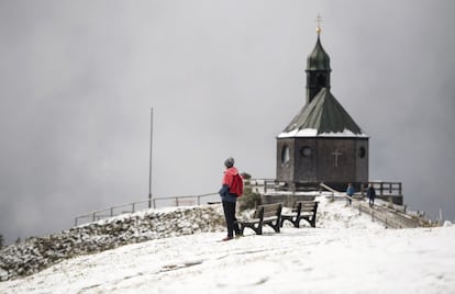 Una mujer admira el paisaje nevado desde el monte Wallberg y junto a la capilla del mismo nombre (Wallbergkapelle) cerca del lago Tegernsee en Baviera.