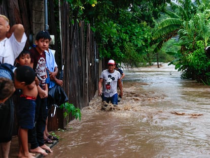 Un grupo de personas entre una de las inundaciones ocasionadas por la tormente tropical 'Max', en Técpan de Galeana.