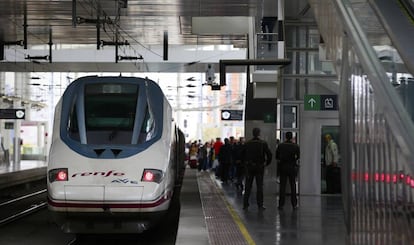 Viajeros en las escaleras mecánicas con sus maletas y un AVE en la estación de Atocha de Madrid.
 
 