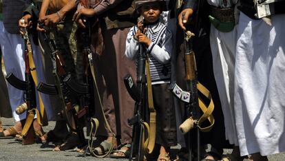 Un niño sostiene un fusil junto a un grupo de rebeldes Huthi, durante un acto de reclutamiento en Saná.