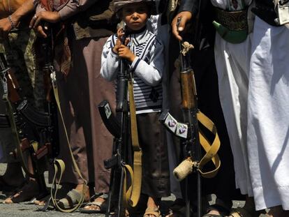 Un ni&ntilde;o sostiene un fusil junto a un grupo de rebeldes Huthi, durante un acto de reclutamiento en San&aacute;.