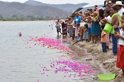 Habitantes de Paso de la Reina lanzan flores al Río Verde durante un festival en 2017.