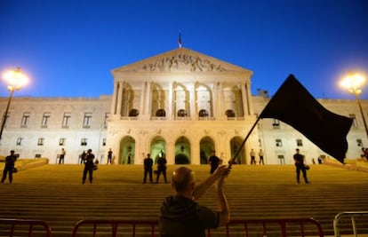 A protestor waves a black flag during a demonstration in front of the parliament building in Lisbon on Saturday.