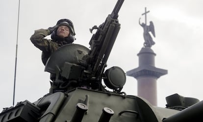 Soldado russo dirige seu veículo militar; ao fundo, o anjo sobre a Coluna de Aleksander, durante o Dia da Vitória, em São Petersburgo.