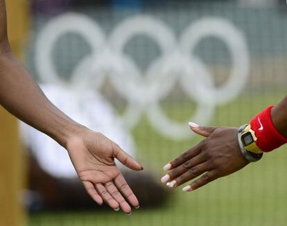 Las tenistas estadounidense Venus y Serena Williams chocan las manos en el partido de dobles contra la República Checa.