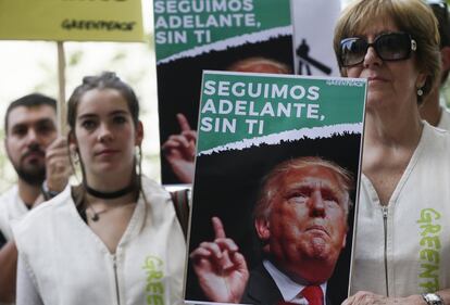Miembros de Greenpeace se concentran en la Embajada de Estados Unidos de Madrid con carteles contra Trump y a favor del acuerdo del que se ha retirado el país estadounidense.