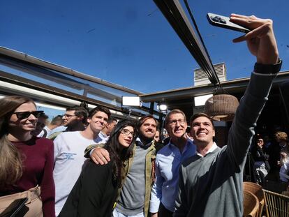 El presidente del PP, Alberto Núñez Feijóo, posa para una foto con jóvenes en un acto de vivienda en Madrid.