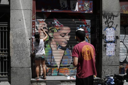 Dos artistas pintan un grafiti en Malasaña.