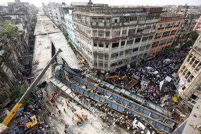 Bomberos y trabajadores de rescate buscan víctimas en la zona de un puente en construcción de Calcuta (India) después de que se viniera abajo.