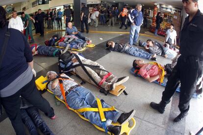 Heridos en el accidente esperan a que sean evacuados de la estación de Once, en Buenos Aires.