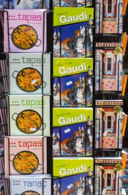 Llibres sobre Gaudí, tapas de la cocina española y guías de Barcelona, en cinco idiomas, a la venta en un quiosco.