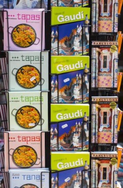 Llibres sobre Gaudí, tapas de la cocina española y guías de Barcelona, en cinco idiomas, a la venta en un quiosco.