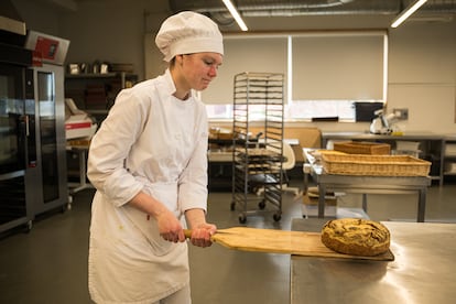 Una alumna de panadería saca del horno una pieza recién hecha.