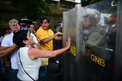 En Caracas, los opositores, vestidos de blanco y llevando banderas venezolanas, se concentraron primero en varios sectores con la meta de llegar a la sede de la Defensoría del Pueblo, en el centro de la ciudad, considerado un feudo chavista, donde hasta ahora no han podido entrar. En la imagen, una opositora se enfrente a unos policías en Caracas.