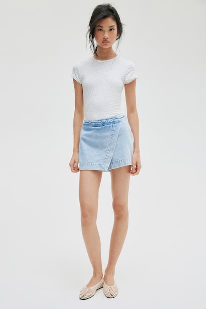 Se puede lucir minifalda vaquera y no tener por qué renunciar a ir cómoda gracias a la reinterpretación en clave skort que hace H&M. Un diseño de silueta cruzada y corte evasé y que está disponible en denim blanco y dos tonos de azules. 
(Comprar 24.99 euros)
