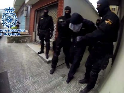 El pederasta (en el centro), es detenido por la policía.