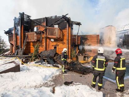 Los bombero intentan apagar los restos del hotel Lodge.