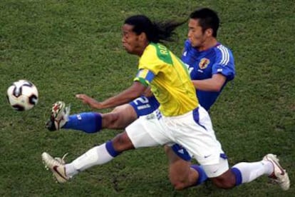 El japonés Kaji despeja el balón ante una internada de Ronaldinho.