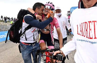 El masajista Josué Arán abraza a Juanpe a su llegada salvando la maglia rosa.