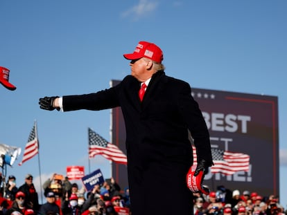 El presidente y candidato a la Casa Blanca, Donald Trump, lanza una gorra durante el mitin de Avoca (Pensilvania), este lunes.