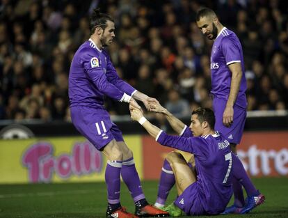 El centrocampista galés del Real Madrid Gareth Bale (i), ayuda a su compañero, el delantero portugués Cristiano Ronaldo (c), ante el delantero francés Karim Benzema (d), durante el partido.
