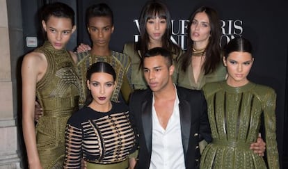 El diseñador de Balmain junto a Kim Kardashian (a su derecha) en una presentación.