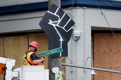 Funcionário retira placa "Black Lives Matter St." em Seattle, EUA.