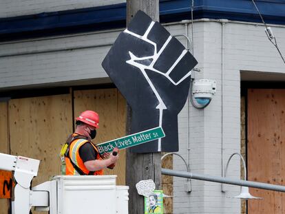 Funcionário retira placa "Black Lives Matter St." em Seattle, EUA.