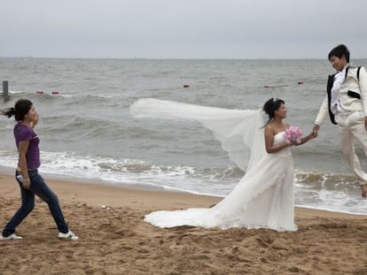 Una pareja de reci&eacute;n casados durante una sesi&oacute;n fotogr&aacute;fica en la playa de Qinhuangdao Beidaihe, al este de China.