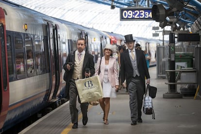 Una pareja camina por el andén de la estación de Waterloo para asistir al hipódromo.